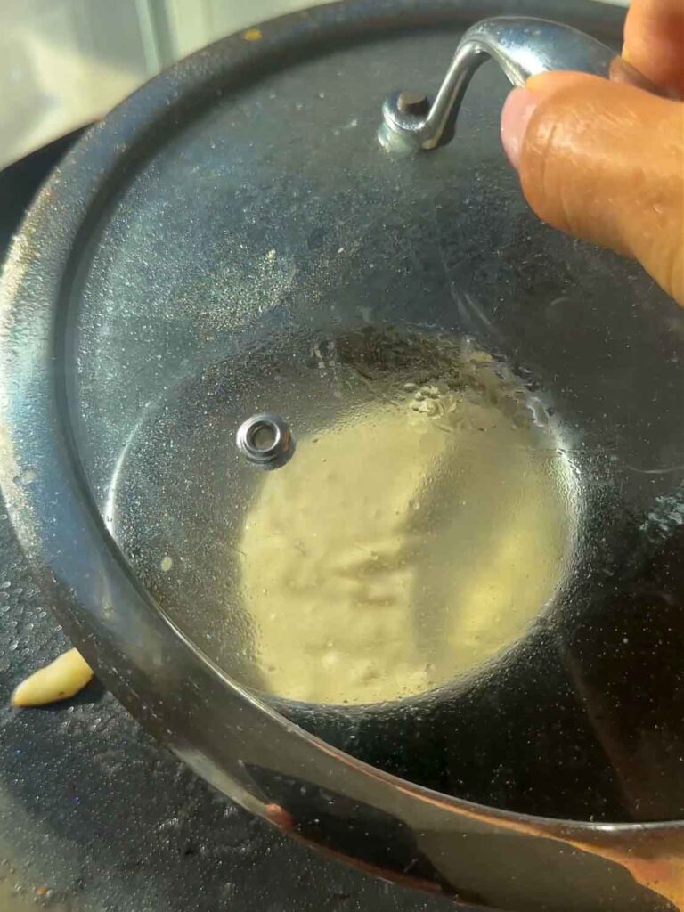 putting lid on top of cooking lemon ricotta pancake